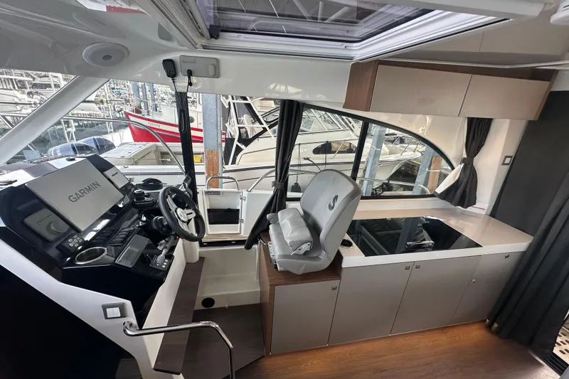 Slide: The Image of Interior of 2023 Beneteau Antares 11 Coupe with helm, Garmin display, and modern cabinetry. - 15