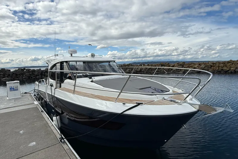 Slide: The Image of 2023 Beneteau Antares 11 Coupe docked at marina under cloudy sky. - 2