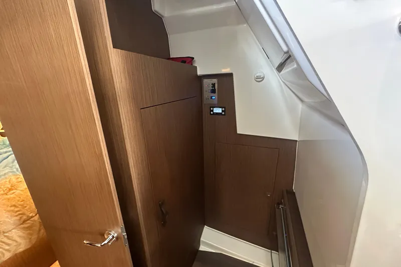 Slide: The Image of Interior view of 2023 Beneteau Antares 11 Coupe, featuring wooden cabinetry and control panel. - 24