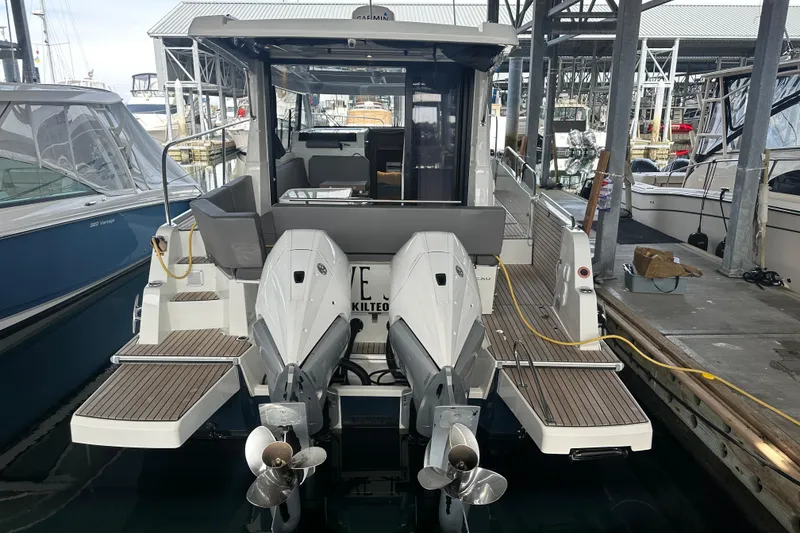 Slide: The Image of 2023 Beneteau Antares 11 Coupe docked, showcasing dual outboard engines and spacious deck. - 4