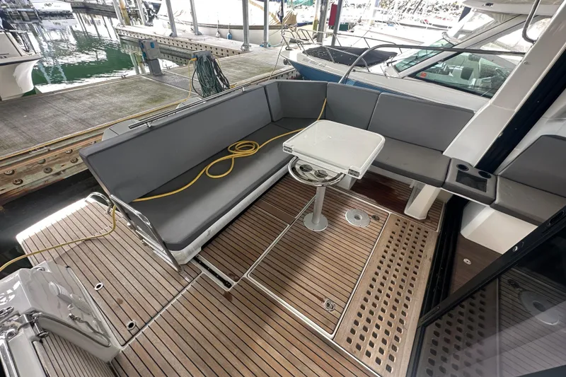 Slide: The Image of 2023 Beneteau Antares 11 Coupe cockpit with teak flooring and gray seating. - 40