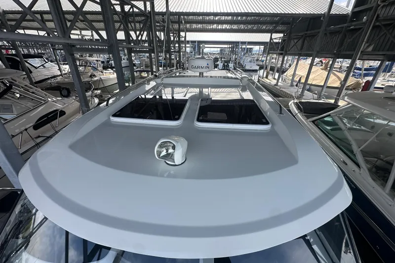Slide: The Image of 2023 Beneteau Antares 11 Coupe in marina, showcasing sleek roof design and Garmin equipment. - 45