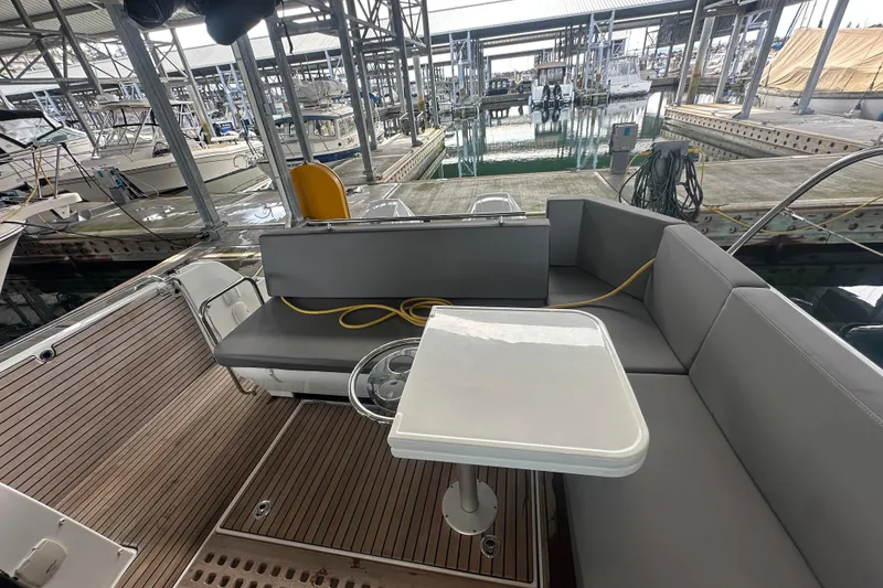 Slide: The Image of 2023 Beneteau Antares 11 Coupe boat interior with seating and table at marina. - 7