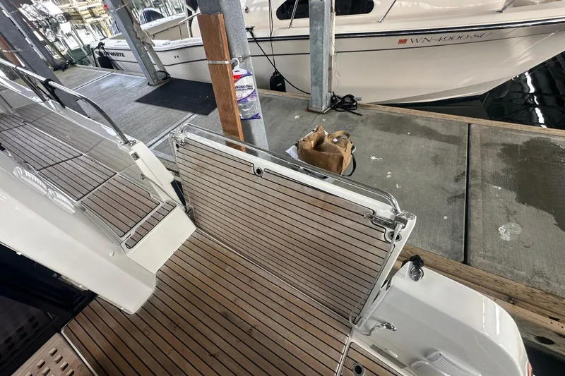 Slide: The Image of 2023 Beneteau Antares 11 Coupe docked, showcasing teak deck and boarding gate. - 8