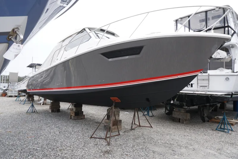 The Image of 2021 Pursuit OS 325 Offshore boat on stands in a marina setting. - 1