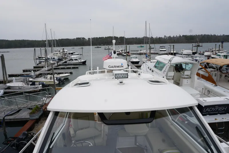 Slide: The Image of 2021 Pursuit OS 325 Offshore boat docked at marina with other vessels. - 10