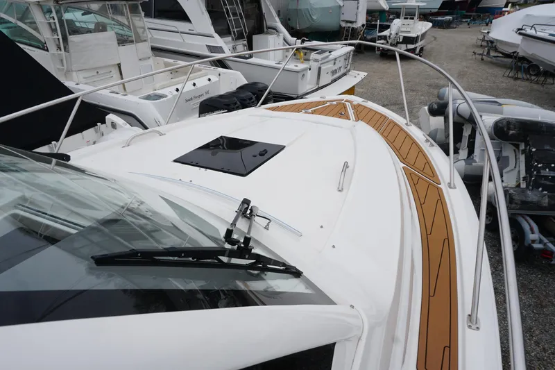 Slide: The Image of 2021 Pursuit OS 325 Offshore boat deck with teak accents in a marina setting. - 13