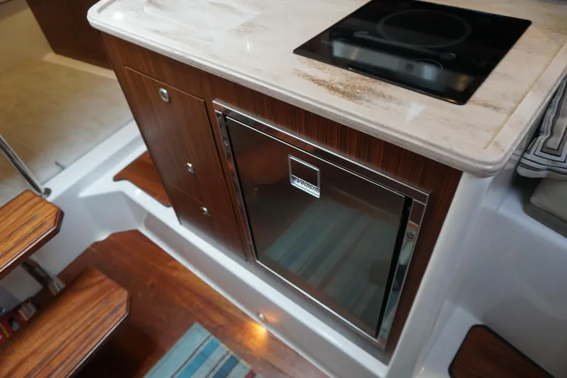Slide: The Image of 2021 Pursuit OS 325 Offshore yacht interior with compact kitchen and modern appliances. - 14
