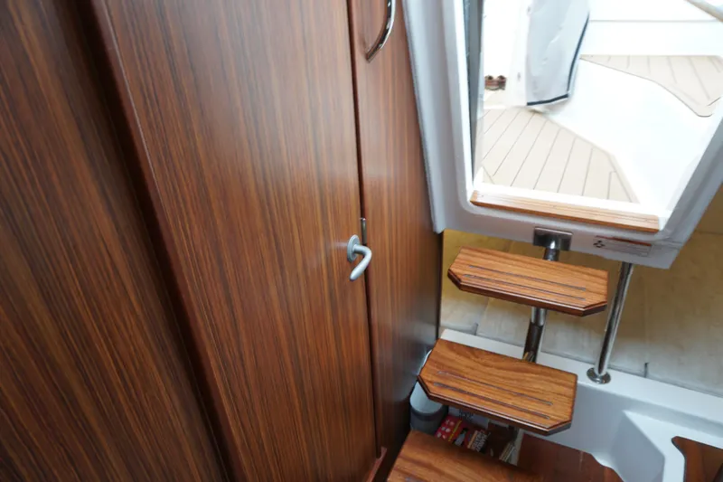 Slide: The Image of Interior view of 2021 Pursuit OS 325 Offshore boat with wooden stairs and cabin door. - 19