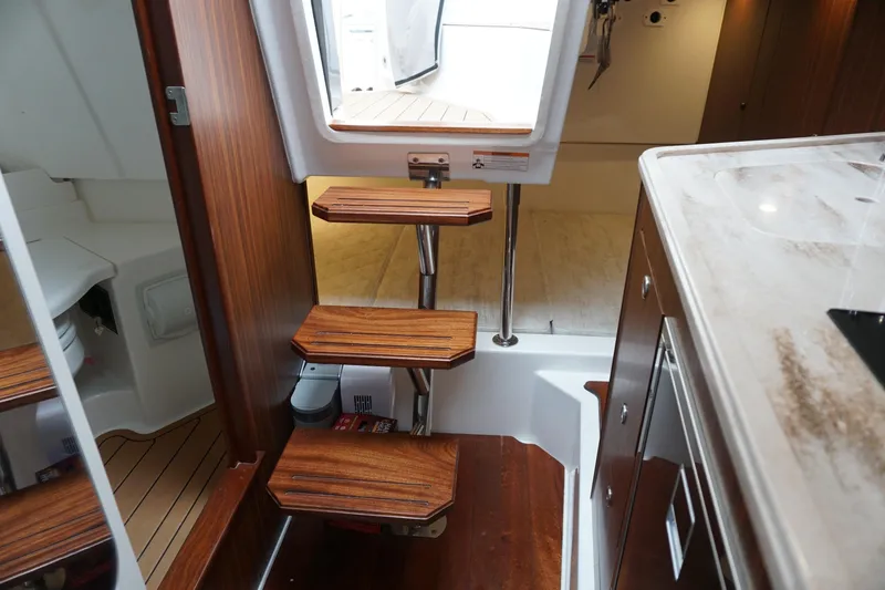 Slide: The Image of Interior view of 2021 Pursuit OS 325 Offshore boat with wooden steps and modern amenities. - 21