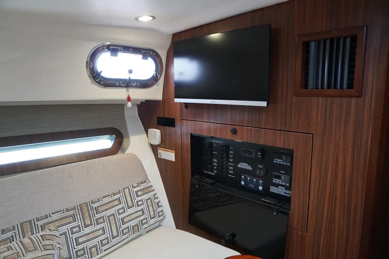 Slide: The Image of 2021 Pursuit OS 325 Offshore cabin interior with TV and control panel. - 23