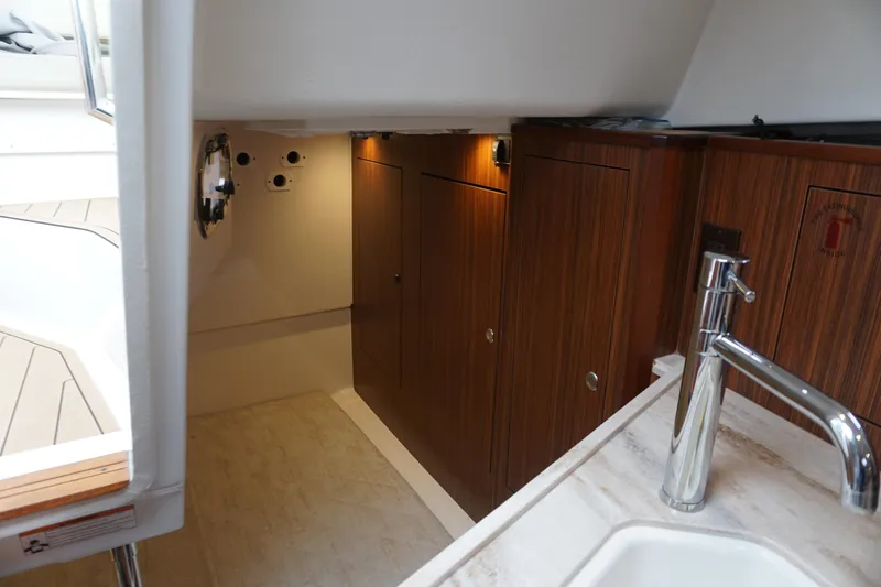 Slide: The Image of 2021 Pursuit OS 325 Offshore cabin interior with wood cabinetry and modern sink. - 25