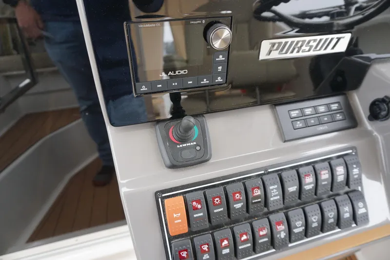 Slide: The Image of Control panel of 2021 Pursuit OS 325 Offshore boat with audio system and switches. - 29