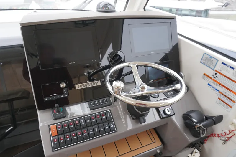 Slide: The Image of Helm of 2021 Pursuit OS 325 Offshore boat with steering wheel and control panels. - 3