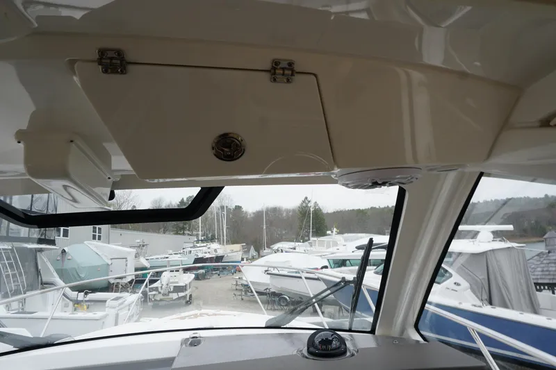 Slide: The Image of Interior view of 2021 Pursuit OS 325 Offshore boat with marina background. - 30