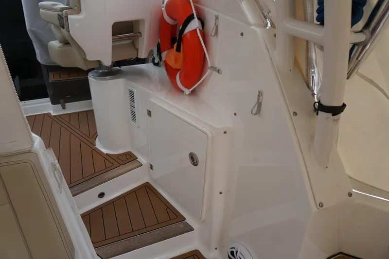 Slide: The Image of 2021 Pursuit OS 325 Offshore boat interior with teak flooring and safety equipment. - 40