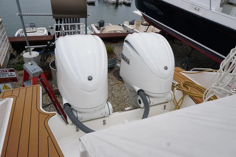 Slide: The Image of Twin Yamaha outboard engines on a 2021 Pursuit OS 325 Offshore boat at a marina. - 44