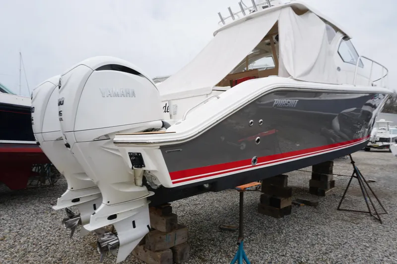 Slide: The Image of 2021 Pursuit OS 325 Offshore boat with twin Yamaha engines on stands. - 45