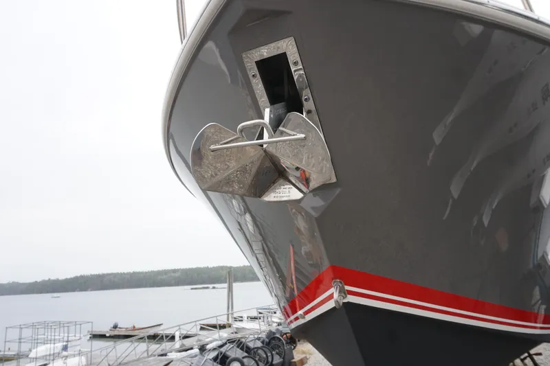 Slide: The Image of 2021 Pursuit OS 325 Offshore boat with anchor, docked by a calm lake. - 46