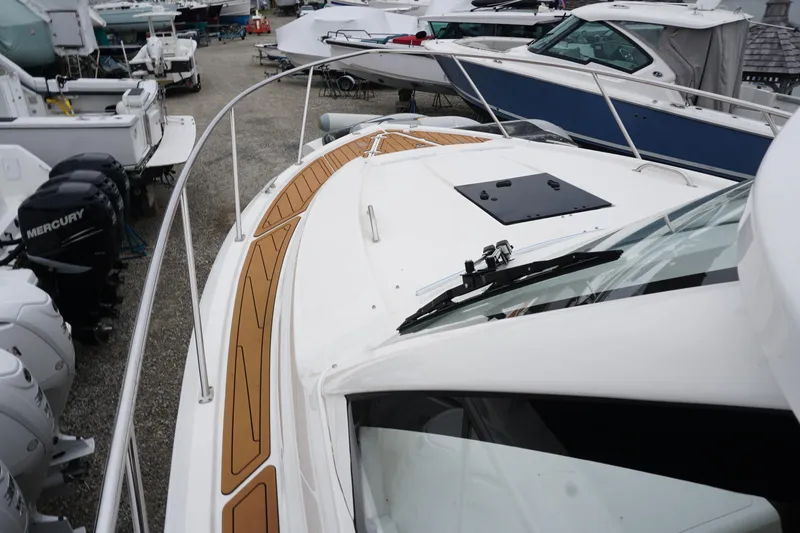Slide: The Image of 2021 Pursuit OS 325 Offshore boat with teak deck, docked among other vessels. - 7