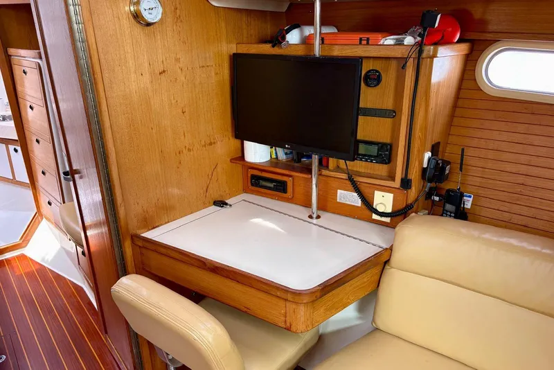 Slide: The Image of Navigation station inside 2000 Catalina 42 MkII sailboat with wood paneling and mounted electronics. - 11