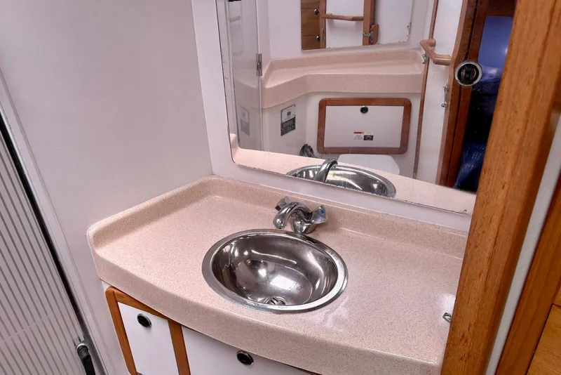 Slide: The Image of Bathroom sink area in a 2000 Catalina 42 MkII yacht, featuring a mirror and countertop. - 15