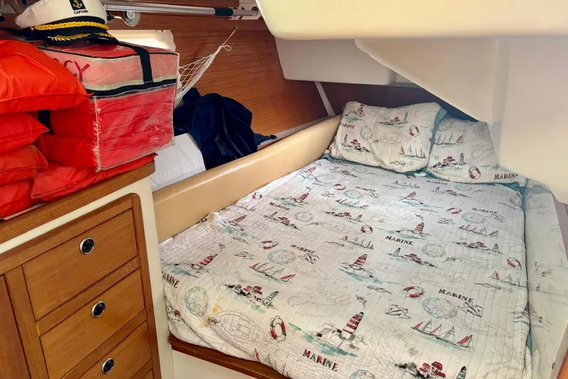 Slide: The Image of Cozy cabin interior of 2000 Catalina 42 MkII sailboat with nautical-themed bedding and life jackets. - 17