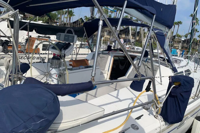 Slide: The Image of 2000 Catalina 42 MkII sailboat with blue canvas covers docked at a marina. - 2