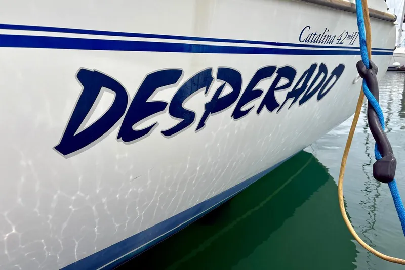 Slide: The Image of Catalina 42 MkII sailboat named "Desperado" docked, reflecting on water. - 20