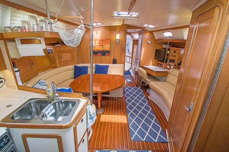Slide: The Image of Interior of a 2000 Catalina 42 MkII yacht with cozy seating and wooden finishes. - 4