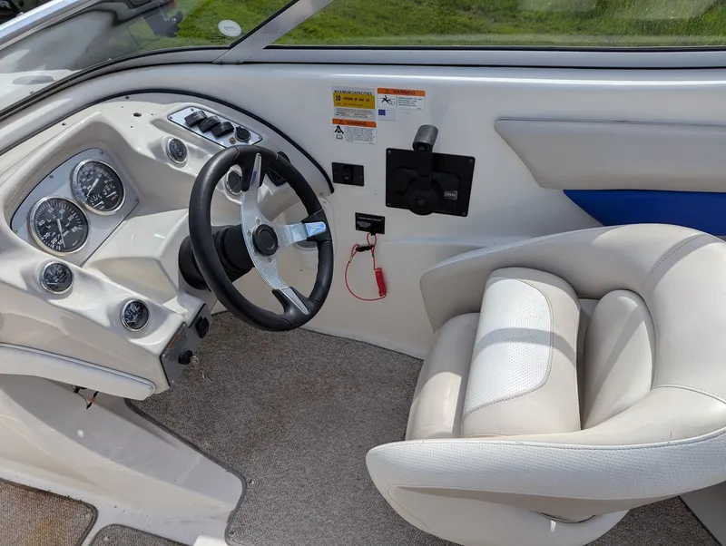 Slide: The Image of Interior of a 2006 Larson Senza 206 boat with steering wheel and seat. - 4