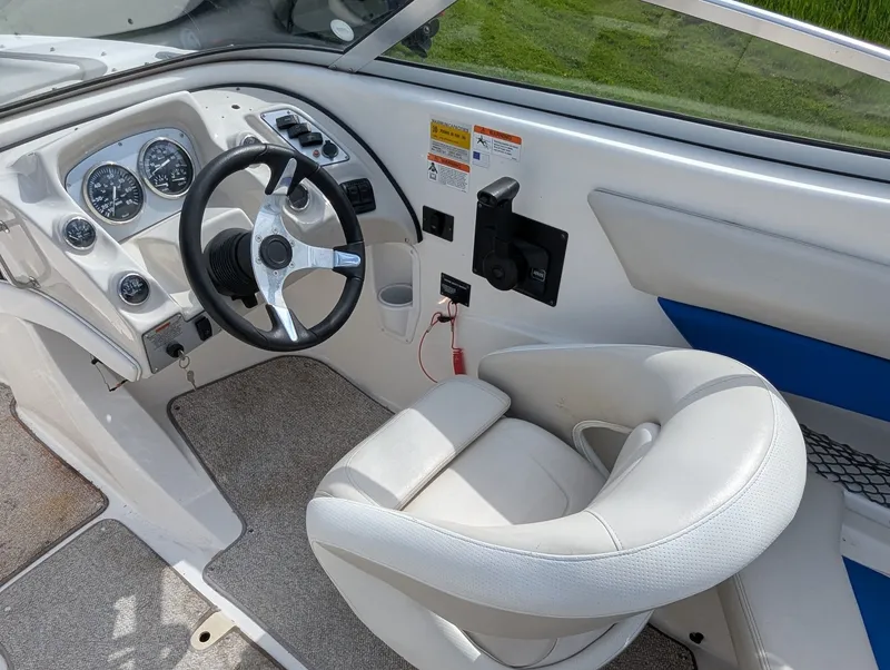 Slide: The Image of Interior of a 2006 Larson Senza 206 boat with steering wheel and seat. - 9