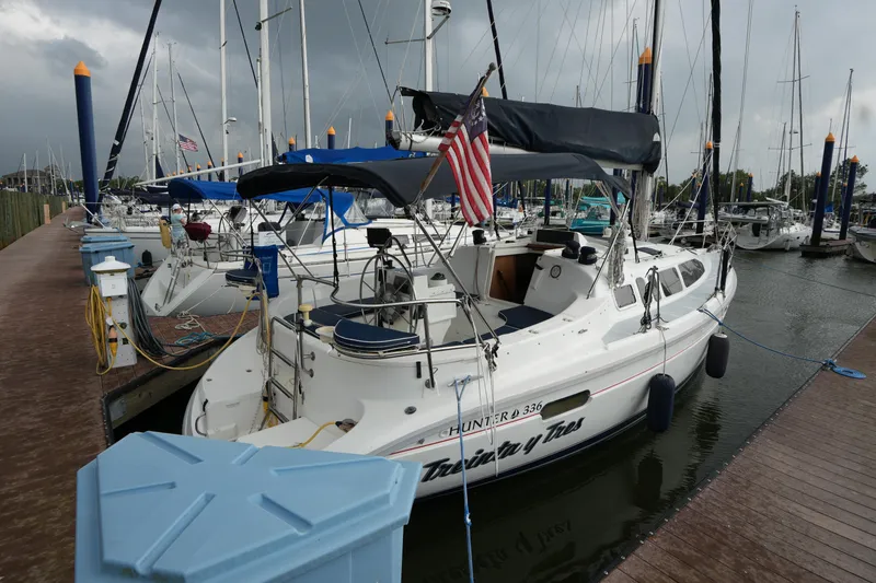 The Image of Sailboat Hunter 336, 1997 model, docked at marina with American flag. - 1