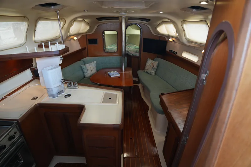 Slide: The Image of Interior of a 1997 Hunter 336 sailboat with cozy seating and kitchen area. - 11