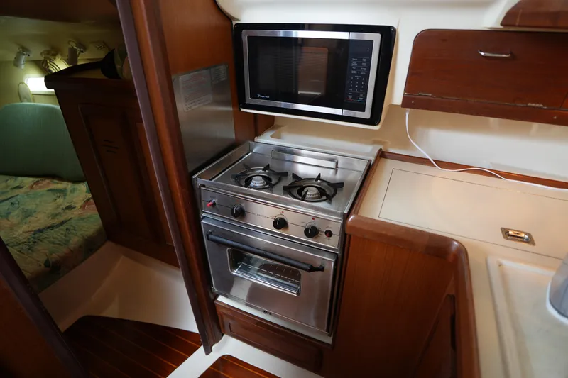 Slide: The Image of Compact kitchen area in a 1997 Hunter 336 sailboat with stove and microwave. - 19