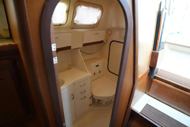 Slide: The Image of Interior of a 1997 Hunter 336 sailboat bathroom with compact design and wooden accents. - 20