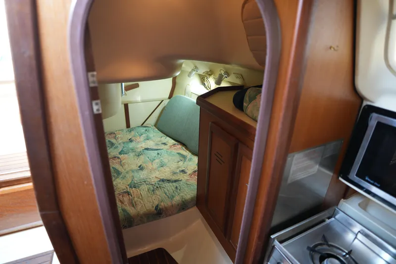 Slide: The Image of Cozy cabin interior of 1997 Hunter 336 sailboat with wood finish and compact kitchen. - 21