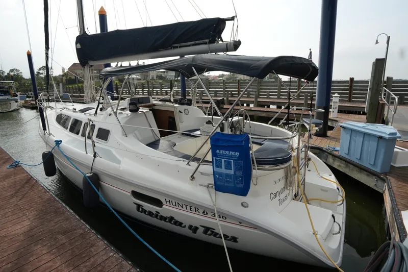 Slide: The Image of Sailboat Hunter 336, 1997 model, docked at marina with blue cover and lifebuoy. - 3