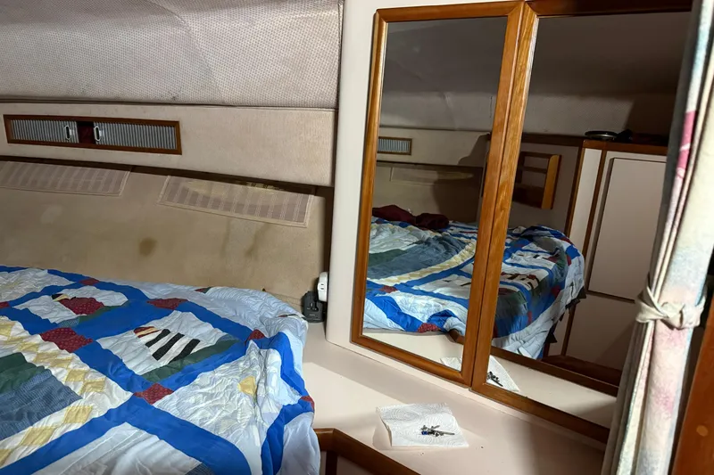 Slide: The Image of Interior cabin of 1989 Sea Ray 340 Express Cruiser with quilted bedspread and mirrored cabinet. - 10