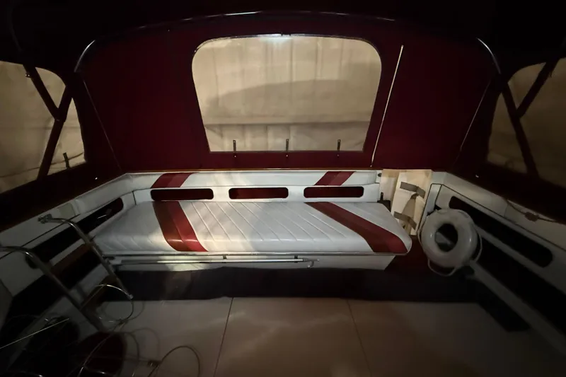 Slide: The Image of 1989 Sea Ray 340 Express Cruiser interior with red and white seating and life preserver. - 12