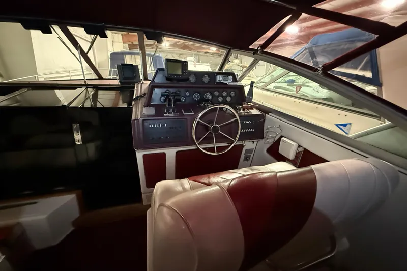 Slide: The Image of 1989 Sea Ray 340 Express Cruiser helm with classic controls and steering wheel. - 13