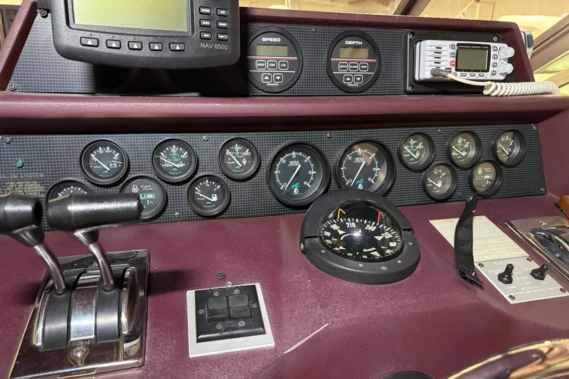 Slide: The Image of Dashboard of a 1989 Sea Ray 340 Express Cruiser with gauges and navigation equipment. - 16