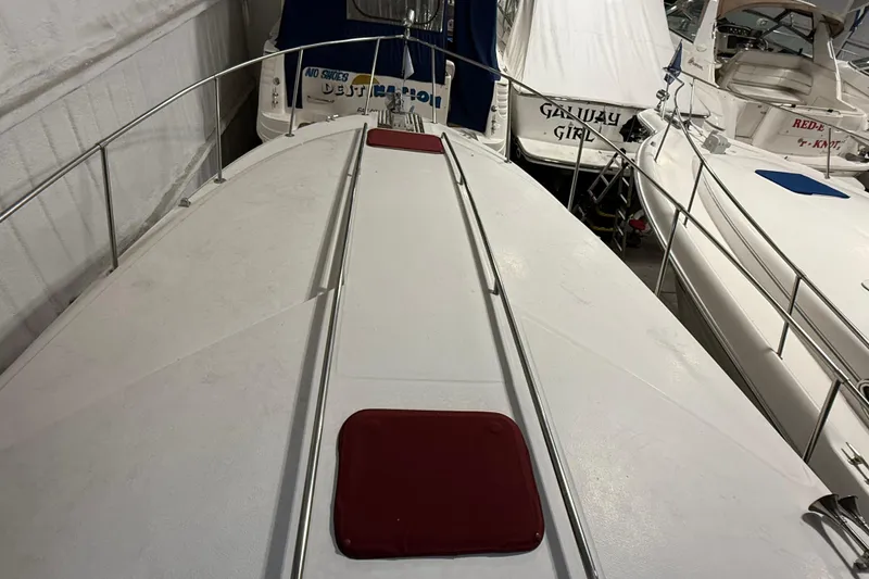 Slide: The Image of 1989 Sea Ray 340 Express Cruiser boat deck with red accents, docked among other boats. - 30