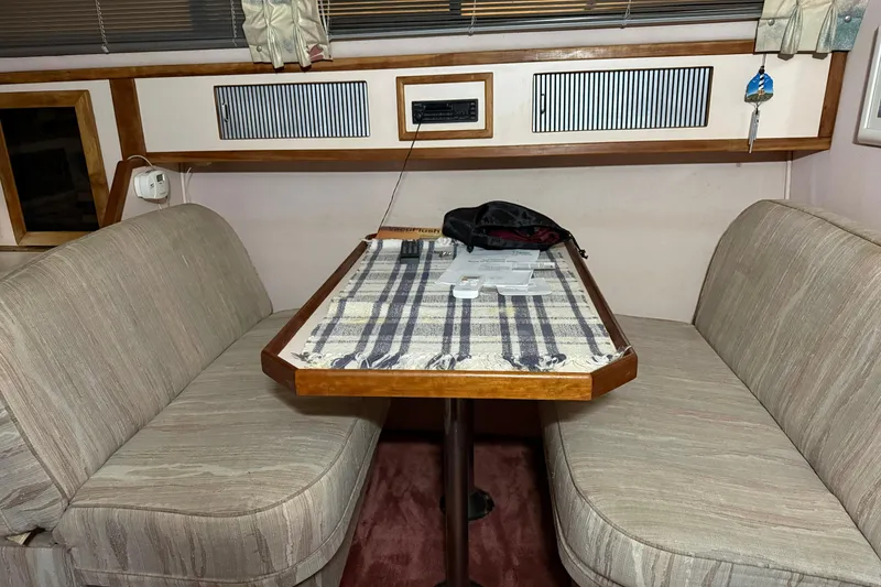 Slide: The Image of Interior dining area of a 1989 Sea Ray 340 Express Cruiser with striped tablecloth. - 5