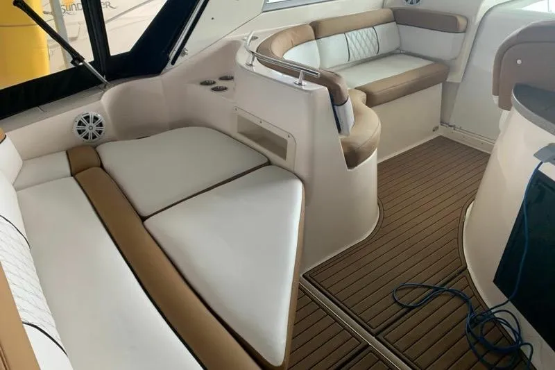 Slide: The Image of 2003 Rinker Fiesta Vee 342 interior with white and tan seating, wood flooring. - 10