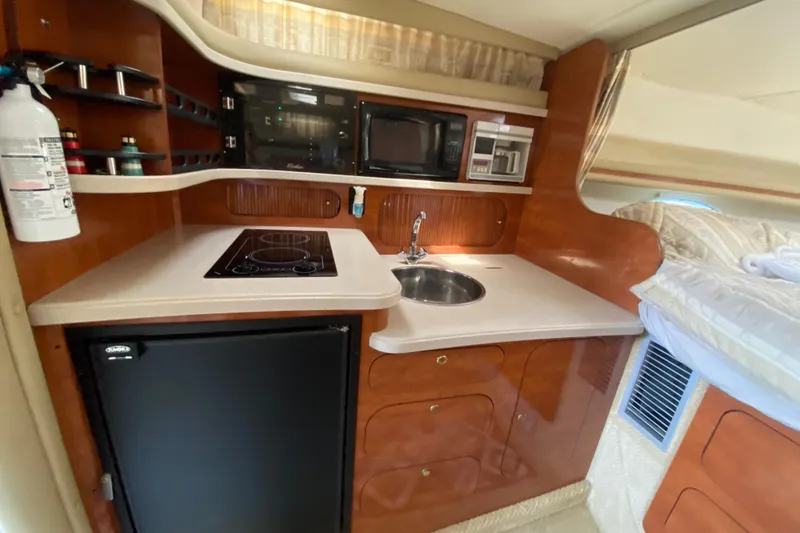 Slide: The Image of 2003 Rinker Fiesta Vee 342 boat interior with kitchenette, stove, sink, and microwave. - 13