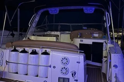 Slide: The Image of 2003 Rinker Fiesta Vee 342 boat interior at night, featuring seating and control panel. - 5