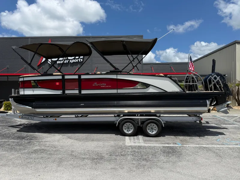 Slide: The Image of 2023 Barletta Lusso 25UE pontoon boat in front of a watersports store. - 9