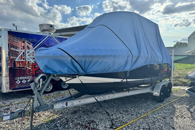 Slide: The Image of 2015 Robalo R200 Center Console boat covered on trailer under cloudy sky. - 4