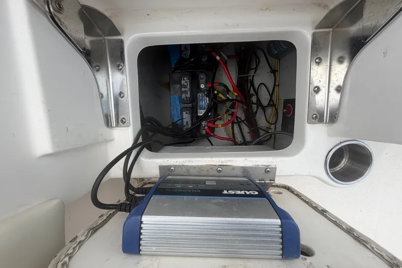 Slide: The Image of 2015 Robalo R200 Center Console boat battery compartment with wiring and charger. - 48